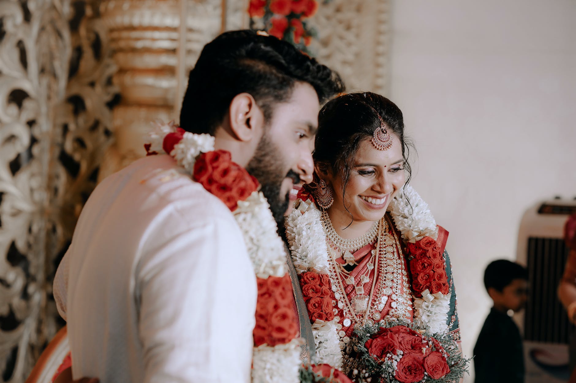 groom and bride decorated with flower garlands at a traditional ceremony